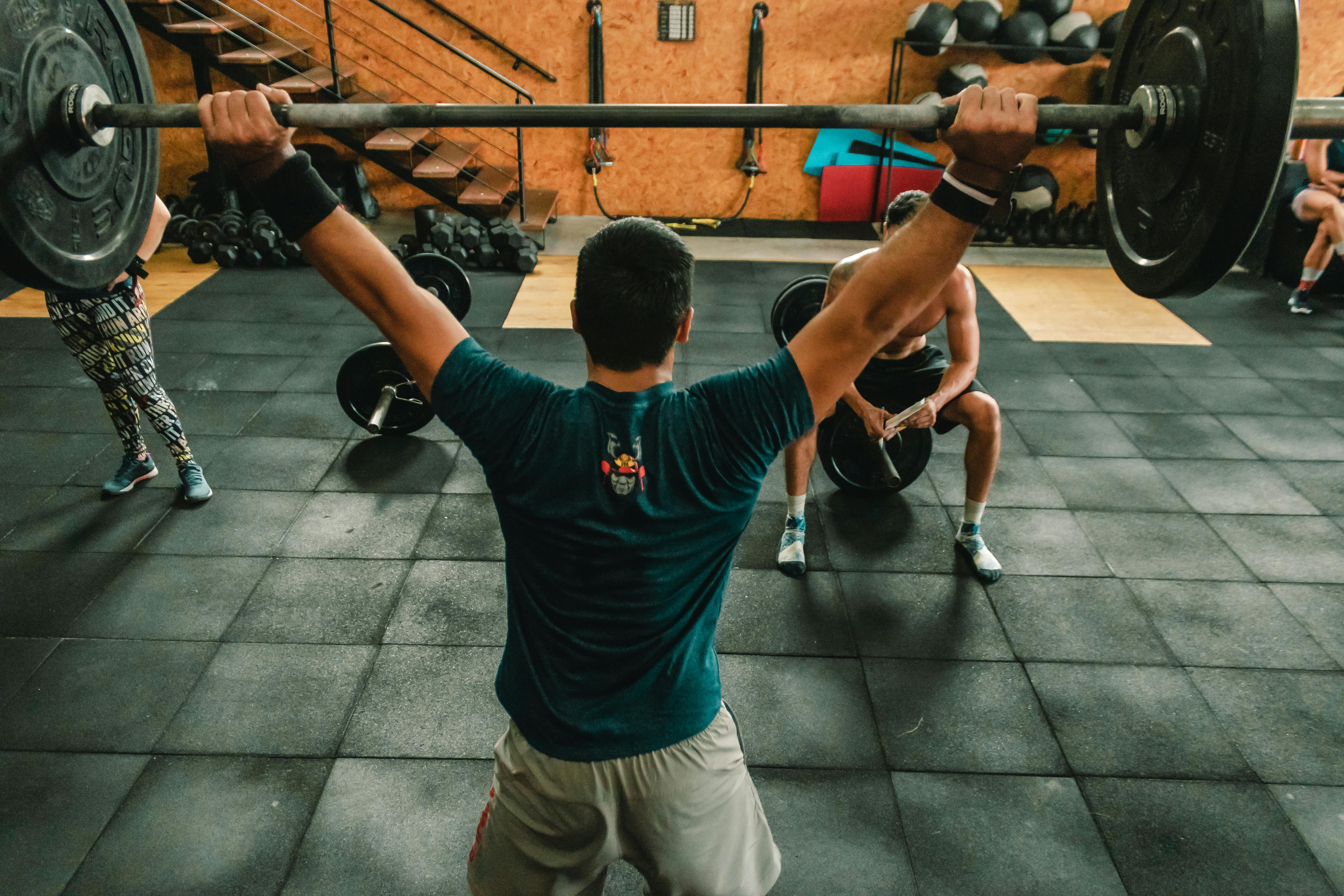 A group of men engaged in a vigorous weightlifting session at a gym.